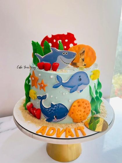 An underwater adventure cake featuring friendly whales and sharks, perfect for a little ocean explorer.