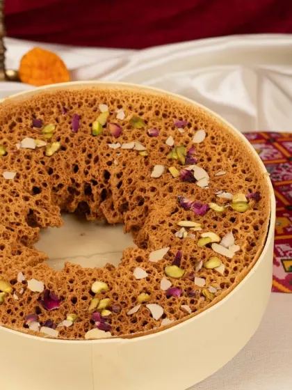 My legendary Paneer Ghewar, a true Rajasthani delicacy. This disc of sweetness is crafted with a crunchy, porous texture and loaded with rich paneer and nuts, making it a festive centrepiece.