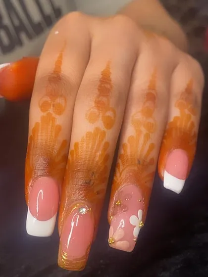 A beautiful set for a special occasion, featuring a classic French manicure paired with henna-adorned hands.