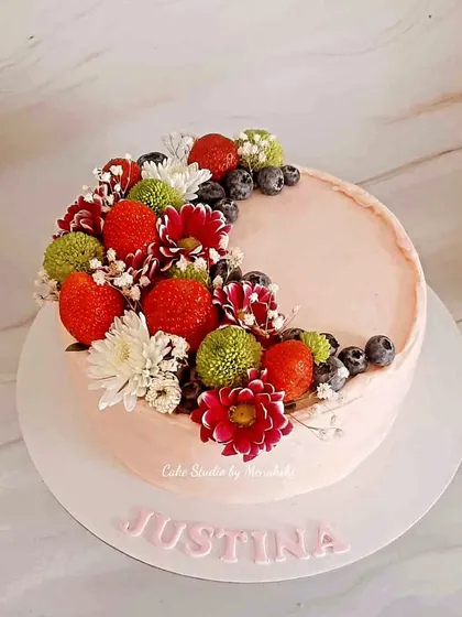 Sometimes, the freshest ingredients make the most beautiful cakes. This simple yet elegant design is topped with fresh strawberries, blueberries, and delicate flowers, creating a dessert that looks as good as it tastes.