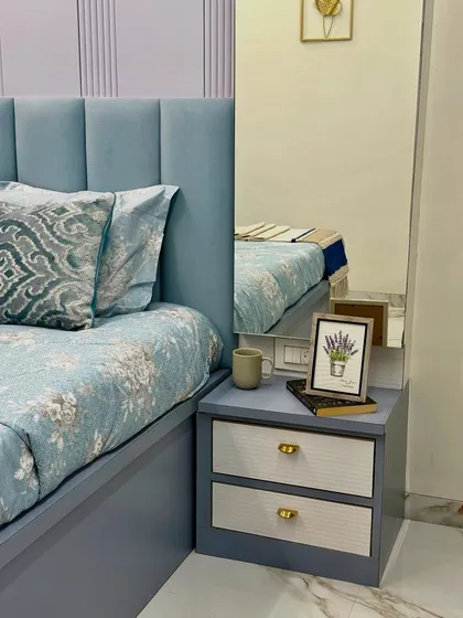 Detail shot of the custom bedside table with a dual-texture finish and elegant gold knobs. The design is complemented by a framed picture and a tall mirror, adding depth to the space.