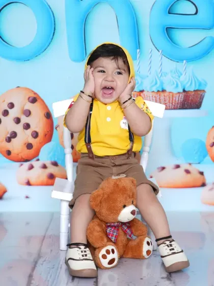 A baby boy makes a funny face, showing off his personality during the cookie-themed shoot. These candid moments are often the most cherished.