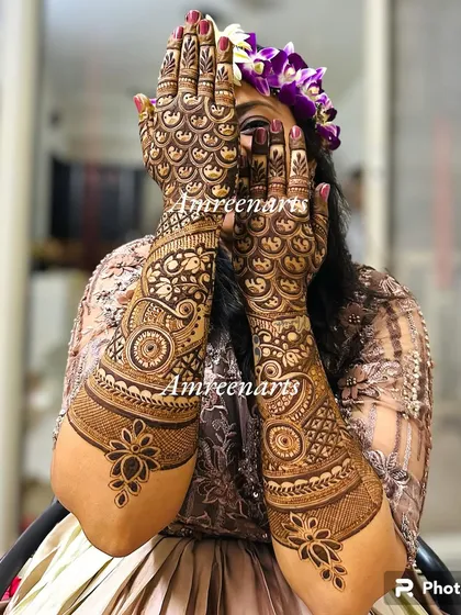 A bride peeking through her hands, which are covered in a beautiful, dense pattern of repeating scallops.