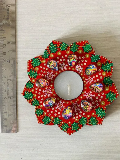 A Christmas-themed floral candle holder in red and green, decorated with snowflake patterns and colorful gems for a festive touch.