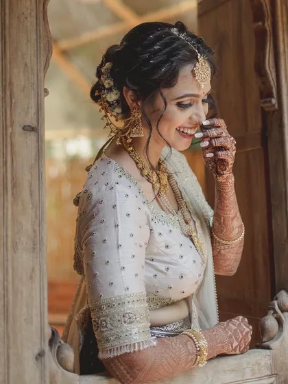 A candid, happy moment of the bride in her off-white and purple half-saree ensemble.