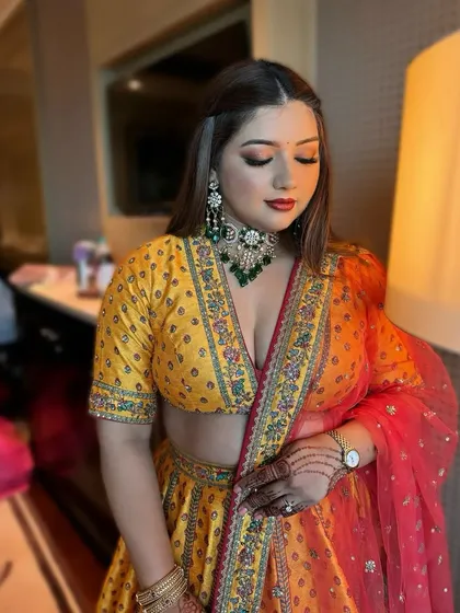 Bridesmaid glam on point. For this bridesmaid, I created a beautiful look with shimmering gold eyeshadow and a bold red lip to perfectly complement her vibrant yellow and red lehenga. It is all about making the entire bridal party feel gorgeous.