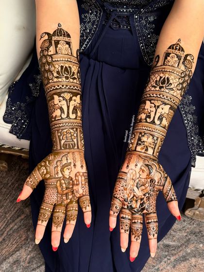 A full bridal mehendi telling a beautiful story. This design includes portraits of the bride and groom, along with elephants, lotuses, and palace architecture, creating a royal narrative.