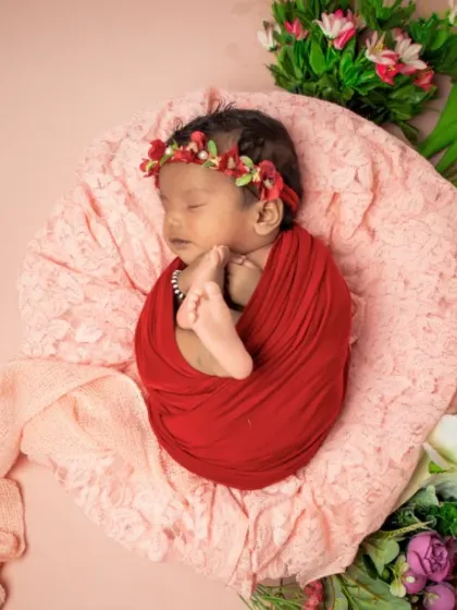 The tiniest flower in the garden. This baby, wrapped in red, is surrounded by a beautiful array of colorful blooms.