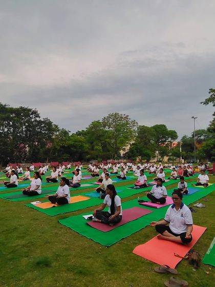 An outdoor yoga session in a beautiful park setting. Practicing together in nature enhances the sense of peace and connection for everyone involved.
