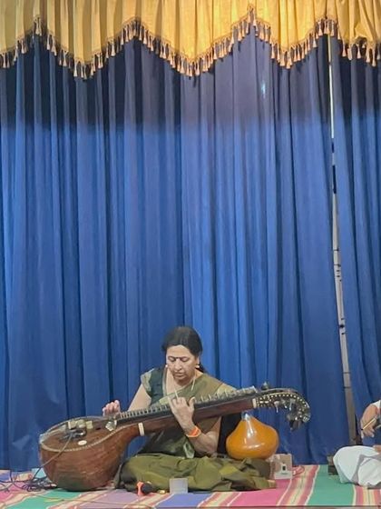 On stage, speaking and performing in memory of Smt. Vimala Rangachar. Music is a powerful way to honor those who have contributed so much to the arts.