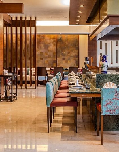 The teppanyaki counter at Tamari restaurant, featuring our custom-upholstered high chairs with beautiful floral patterns. The design adds a touch of elegance and comfort to the interactive dining setup.