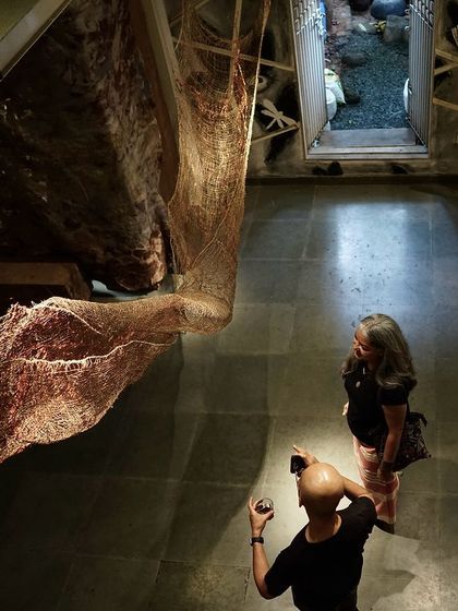 An overhead view of the 'Confluence' installation, where visitors engage with our large-scale fiber sculptures. The work is a continuous dialogue with materials, a process of forming, connecting, and discovering the narrative possibilities inherent in hemp, jute, and copper.