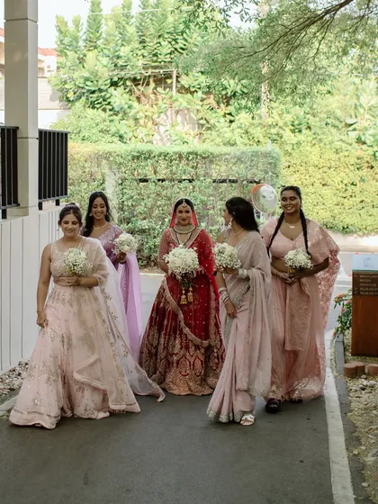 The bride and her squad walking together, sharing a laugh. A candid, happy moment that captures the easy bond of friendship.