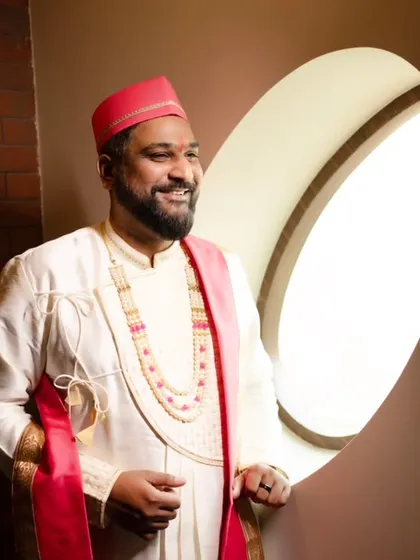 A smiling portrait of the groom, lit beautifully by a nearby window.