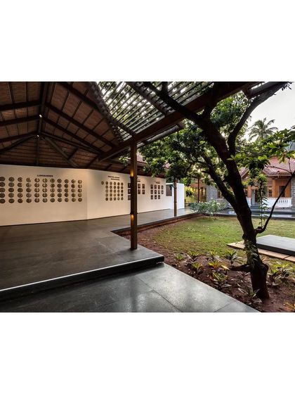 The entrance to the KLE Centenary Museum, where a new pavilion extends from the restored colonial building into the landscape. This outdoor gallery space allows the museum's narrative to begin before one even steps inside.