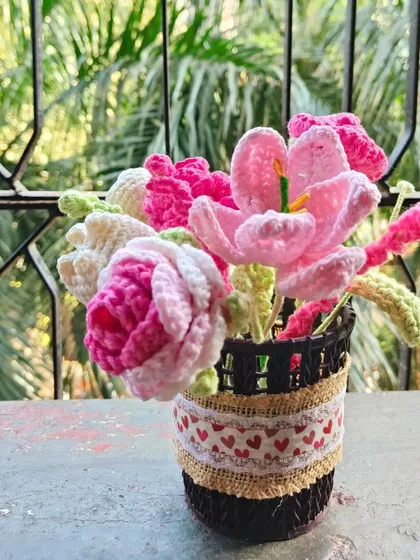 The detail on the basket itself, with the burlap and heart-printed ribbon, adds a rustic and charming touch to the flower arrangement.