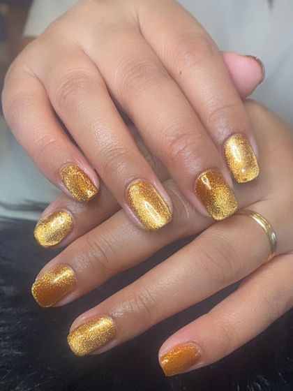 A rich, golden maple cat eye polish on short, natural nails.