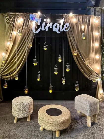 A full view of the chic photo booth we designed for a commercial client's festive celebration. The golden drapes and hanging lanterns create a warm and luxurious feel.