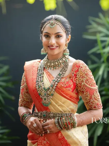 A quintessential South Indian bridal look that feels both classic and fresh. This bride is radiant in a timeless red and cream Kanjivaram saree, which I paired with a heavily embroidered blouse featuring a delicate net back for a touch of modern grace.