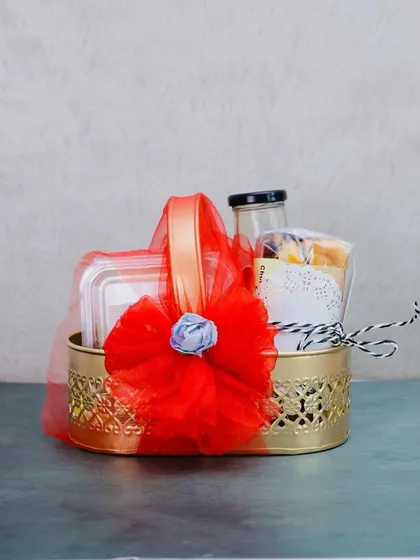 A beautifully decorated hamper perfect for Diwali. This golden basket is wrapped in festive red tulle and filled with a selection of our handmade goodies, making it a warm and joyful gift.