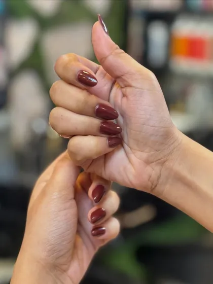 Another look at the rich mocha brown nails, showing the smooth application and how the color complements the client's skin tone.