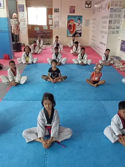 Students perform the butterfly stretch, an important exercise for hip flexibility essential for kicking.