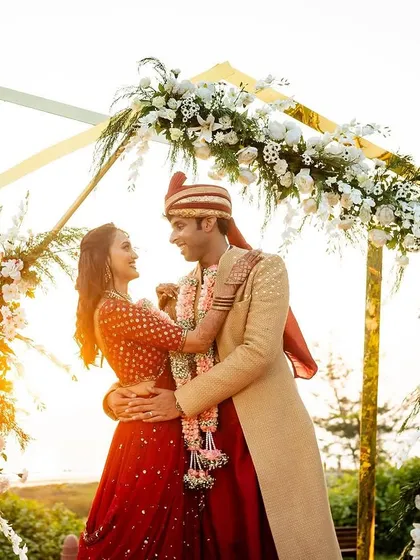 A golden hour Varmala ceremony set against the sea in Goa. We designed this elegant floral arch to capture the warm, romantic light, creating a picture-perfect moment for Aeshna and Anirudh as they exchanged garlands.