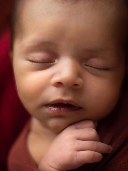 A simple, peaceful close-up of a newborn's face. I use soft lighting to highlight their perfect features, from their eyelashes to their tiny lips.