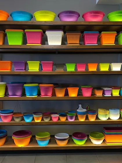 I stock a huge variety of lightweight and durable plastic planters. These shelves show just a fraction of the colors and shapes available, from bright neons to simple pastels, ensuring you'll find the perfect match for your decor.
