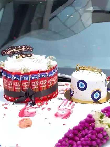 The two cakes on the hood of the new car, ready for the celebration.