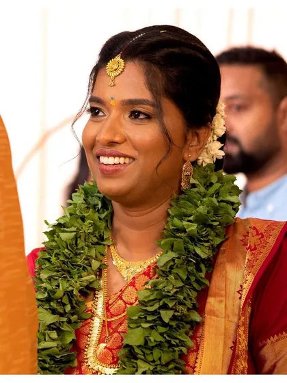 A close-up of Jisha's Malayali bridal look. The makeup is kept true to her skin tone, with defined eyes and a warm smile.