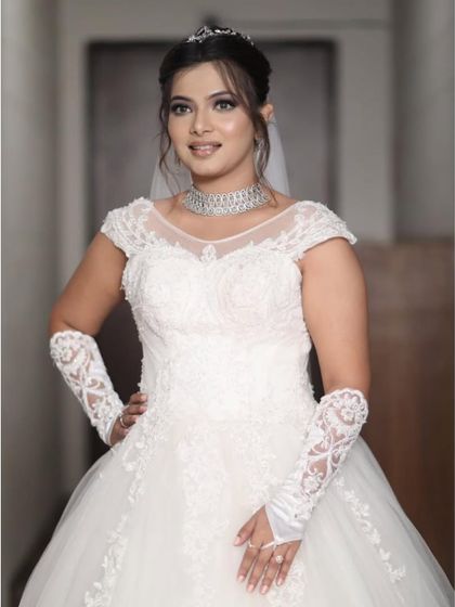 A closer view of the white wedding gown's bodice, showing the intricate lacework and illusion neckline. Renting allows you to wear a high-quality, detailed gown like this for a fraction of the purchase price.