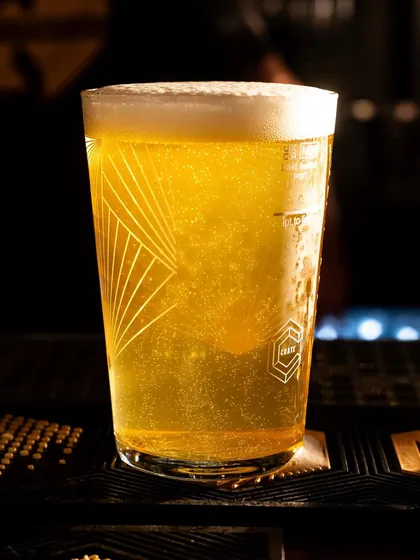 A pint of Crate Brewery's lager, with the light catching the bubbles and the golden color. The shot captures the simple perfection of a well-poured beer.