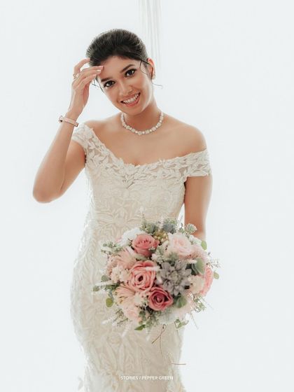 A bright and happy portrait of the bride, her smile infectious as she holds her beautiful bouquet.