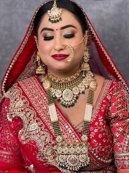 A close-up of the same bride, her eyes closed to showcase the shimmery golden eye makeup that complements her jewellery.