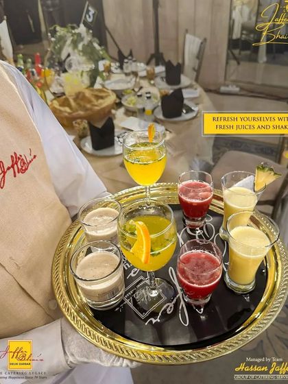 Refresh yourselves with our fresh juices and shakes. A server presents a tray of colorful, freshly prepared beverages, offering a cool and revitalizing option for guests during your event.
