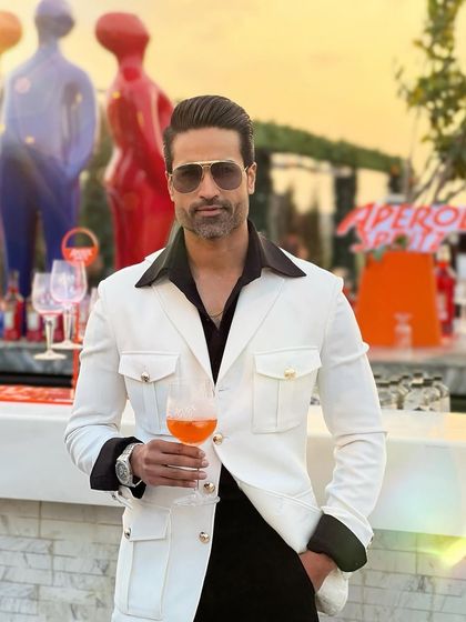 Enjoying a sunset cocktail in our white Viaggio jacket. The gold-button details on the pockets add a touch of luxury.