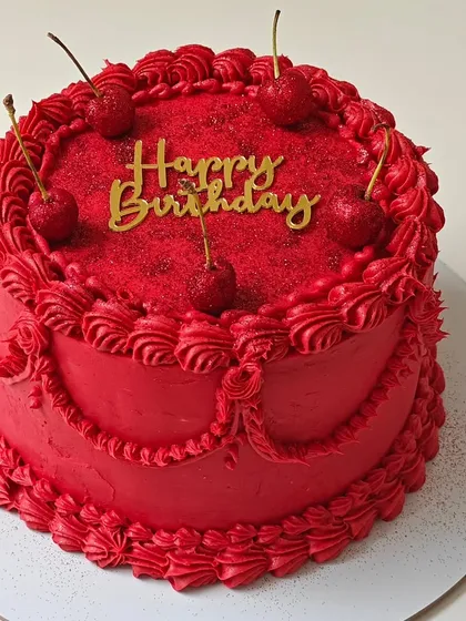 A bold and beautiful vintage-style cake in a striking red color. The intricate piping and glittery cherries make this a simple yet glamorous choice.