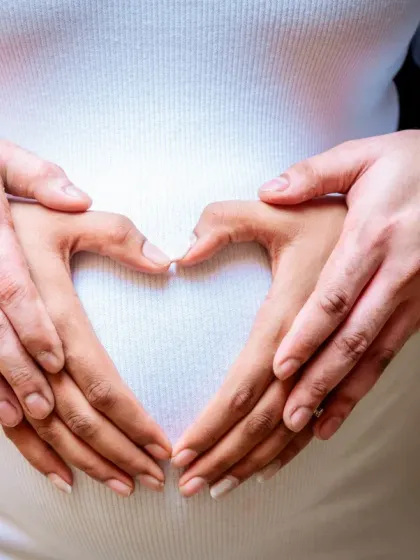 Sometimes, the simplest gestures tell the biggest stories. This classic heart-hands pose is a symbol of the love that already surrounds your little one. It's an intimate and iconic shot that every parent treasures.