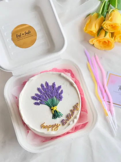 A simple and beautiful birthday bento featuring a hand-piped lavender bouquet tied with a yellow ribbon. The gold "happy birthday" script adds an elegant touch.