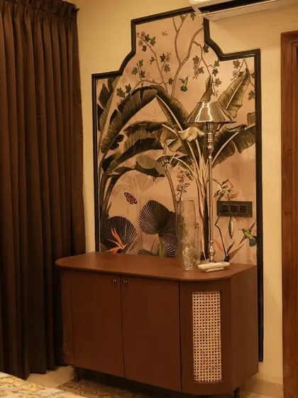 This image shows a custom-designed wooden console and a beautiful wall panel with tropical-themed art, framed in a traditional arch shape. The ornate white door adds to the classic charm.