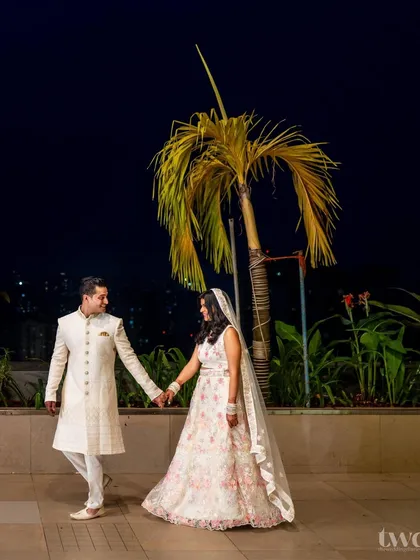 A lovely walking portrait of the couple against the night sky and palm trees, hand in hand.