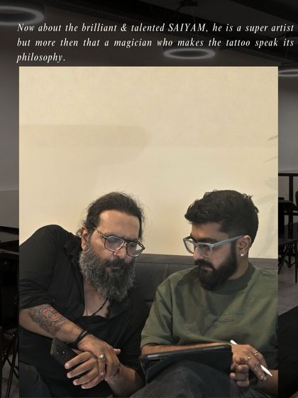 A meeting of minds. The client and artist deep in discussion, ensuring the philosophy behind the tattoo is perfectly captured in the art.