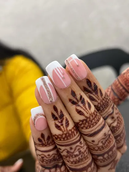 A beautiful bridal nail set. These square-shaped extensions feature a modern white French design accented with delicate lines of silver glitter, perfectly complementing the intricate henna design.