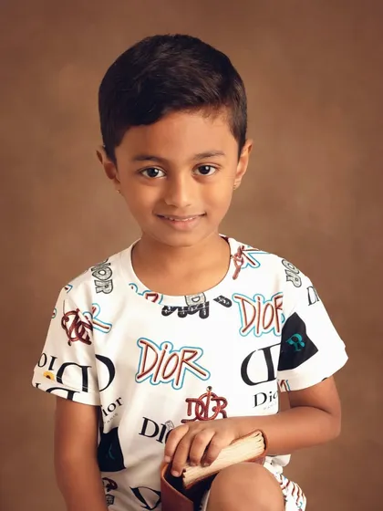 Sometimes the simplest portraits are the most powerful. This is a clean, classic headshot from a kids' apparel shoot, focusing on his bright expression and the details of the designer shirt.