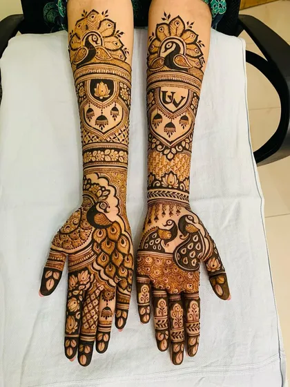 This design is filled with auspicious peacock and lotus motifs. The couple's initials "UV" are also included, making it a personalized yet traditional choice for a bride.