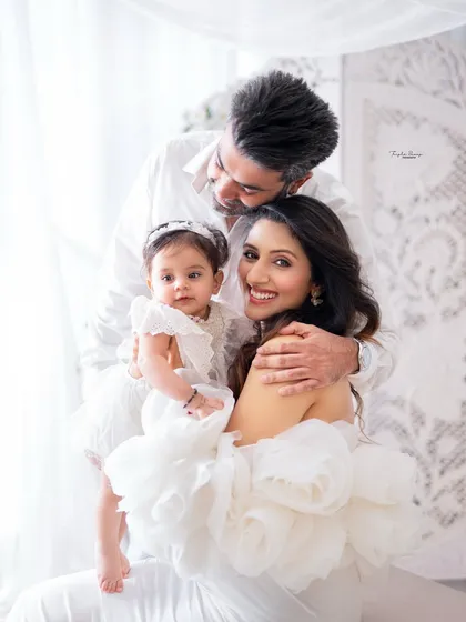 There's nothing more special than the bond between parents and their baby. This intimate family portrait, styled in classic white, captures the quiet, tender love that fills these early years.