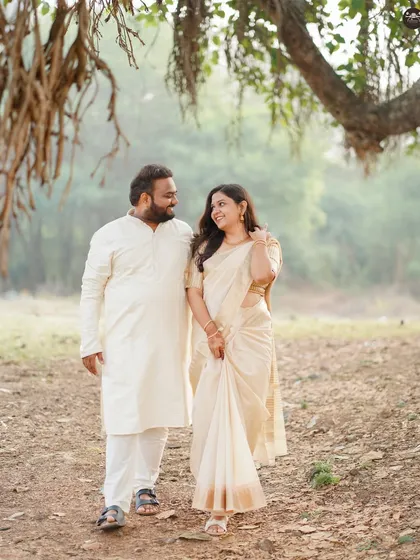A natural, walking shot of the same couple under a large tree on the heritage grounds. This shows the blend of architecture and nature that many heritage sites offer.