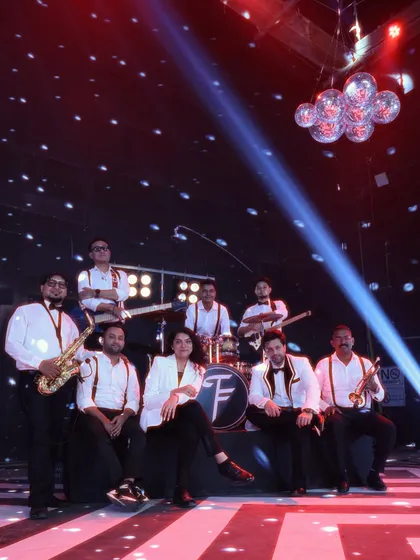 Here we are, the full 10-piece ensemble, ready for the show. This shot showcases our complete lineup, from vocalists and guitars to our powerful horn section. We are a professional, tight-knit crew obsessed with delivering a flawless performance.