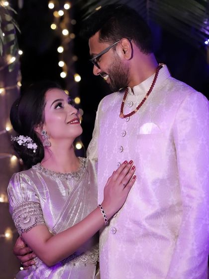 A romantic couple shot from a reception. The bride's makeup is soft and ethereal, matching her silver saree.